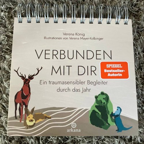 Auf diesem Foto ist das Cover des Jahresbegleiters von Verena König abgebildet. Er heißt "Verbunden mit dir". Der Hintergrund ist grau. Es sind ein Hirsch, ein Hase, ein Bär uns ein Otter abgebildet. Gezeichnet.